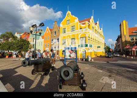 Cannoni storici sul lungomare. Il Penha Building è stato costruito nel 1708 in stile coloniale olandese ed è ora un grande magazzino all'angolo con Handelsk Foto Stock