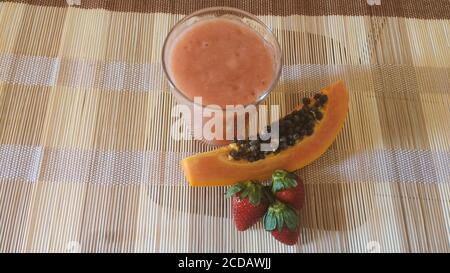 Vitamina vegana sul tavolo - fragola, papaya e banana mix. Foto Stock