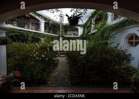 Il giardino e il cortile dell'Hotel Santo Tomas a Chichicastenango, Guatemala. L'hotel è decorato con motivi religiosi cattolici e ne ha molti Foto Stock