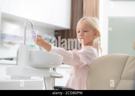 Un primo piano di una bambina in un ufficio dentista. Concetto di dentisti in visita per i bambini. Concetto di assistenza sanitaria dei denti. Foto Stock