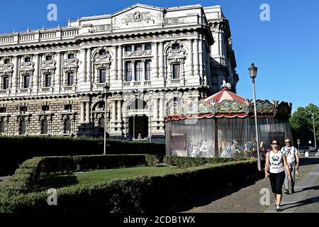 Coppia di turisti adulti che indossa le maschere Coronavirus Covid 19, camminando di fronte ad una giostra tradizionale chiusa durante il blocco. Roma, Italia, Europa. Foto Stock