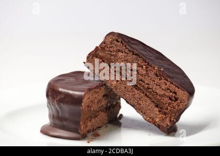 Tipico Alfajor argentino di cioccolato scuro tagliato al centro dove si può vedere l'interno del cioccolato e il ripieno di dulce de leche. Foto Stock