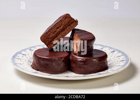 Tipico Alfajor argentino di cioccolato fondente tagliato al centro dove si può vedere l'interno del cioccolato e il riempimento di dulce de leche Foto Stock