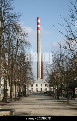 BRECLAV, CZECHIA - 16 MARZO 2013: Strada principale di breclav, con il suo iconico camino gigante dalla zona industriale della città. Breclav è una città cecoslovacca Foto Stock