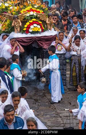 Giovani chierichetti swing bruciatori di incenso nella processione cattolica della Vergine del Carmen in San Pedro La Laguna, Guatemala. Le donne nella tradizionale può Foto Stock