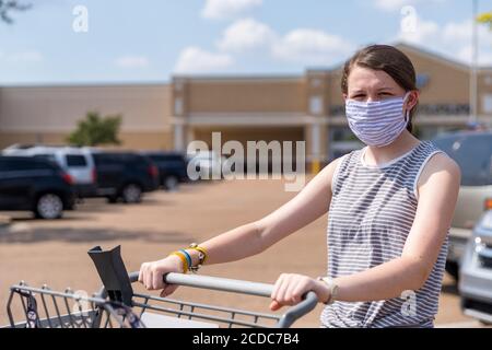la giovane donna indossa la maschera mentre si acquista durante la pandemia Foto Stock