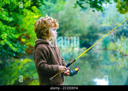 Ritratto di carino bambino ragazzo di pesca. Capretto con la bobina che gira. Foto Stock