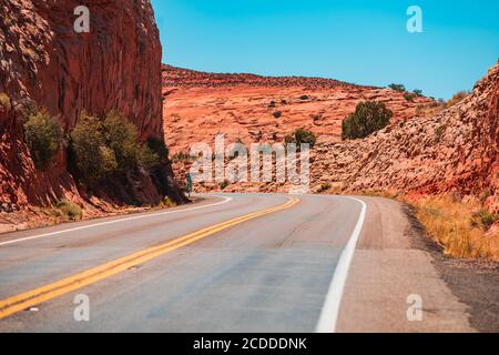 Strada contro le alte rocce. Long Desert Highway California. Foto Stock