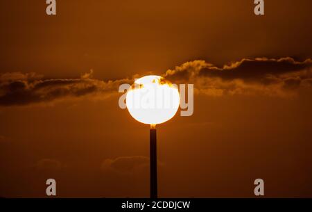 Solar Power. I tramonti dietro il camino di una centrale elettrica a Melbourne Australia . Foto Stock