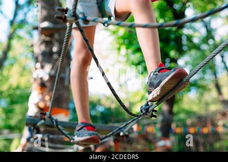 Rope Park. Close (Chiudi) - i piedi di un bambino che oltrepassa un ostacolo. Foto Stock