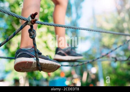 Rope Park. Close (Chiudi) - i piedi di un bambino che oltrepassa un ostacolo. Foto Stock