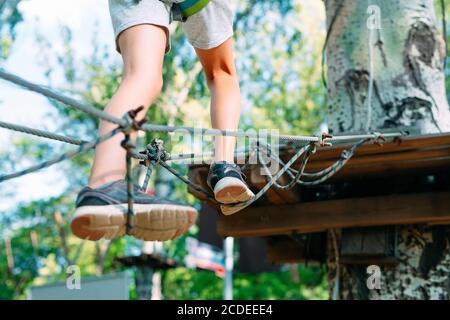 Rope Park. Close (Chiudi) - i piedi di un bambino che oltrepassa un ostacolo. Foto Stock