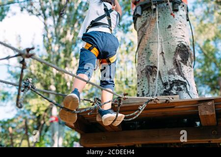 Rope Park. Close (Chiudi) - i piedi di un bambino che oltrepassa un ostacolo. Foto Stock