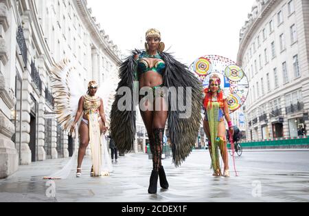 Un trio di ballerini di soca caraibici, Donna Cupid-Thuedi, Andrea Wallace e Fiona Compton, intrattengono i passanti mentre Samsung sveil sul Piccadilly Circus guarda un trailer per il primo Carnevale di Notting Hill digitale di Londra. Foto Stock