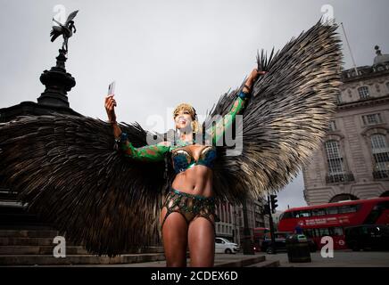Un ballerino caraibico Andrea Wallace intrattiene i passanti, mentre Samsung sveil sul Piccadilly Circus presenta un trailer per il primo carnevale digitale di Notting Hill, Londra. Foto Stock