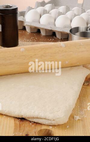 Pasta per pizza o biscotti che vengono arrotolati su un tagliere Foto Stock