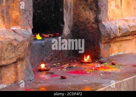 Immagine colorata di pietra santuario indù con candele brucianti, polvere di colore e bastoni di joss nel tempio di Sri Brihadeeswara, Thanjavur (Tanjore), Tamil Nadu, Foto Stock