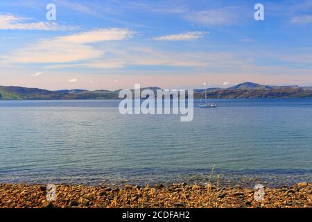 Vista panoramica da Applecross di mare calmo e uno yacht a vela in una bella giornata estiva con l'Isola di Rassay sullo sfondo. Highlands scozzesi Foto Stock