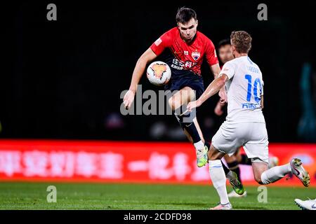 Il calciatore norvegese Ole Selnaes di Shenzhen F.C., a sinistra, protegge la palla durante la sesta partita della Super League Cinese 2020 (CSL) contro Dalian Professional F.C., città di Dalian, provincia di Liaoning della Cina nordorientale, 20 agosto 2020. Shenzhen F.C. ha sconfitto Dalian Professional F.C. con 3-2. Foto Stock