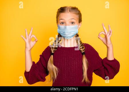 Primo piano-in su ritratto di lei bella attraente grazioso pre-teen ragazza che indossa una garza maschera che mostra ok-segno mers cov test sano isolato sopra Foto Stock