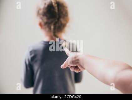 Bambino puntando il dito contro una vittima sfocata e irriconoscibile e parlando dietro. Concetto di bullismo. Foto Stock