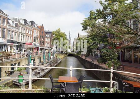 Canale, ponte, barca, strada, negozi con la chiesa di Sint-Bonifatiuskerk sullo sfondo a Leeuwarden, Friesland, Paesi Bassi. Agosto. Foto Stock