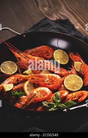 Gamberi crudi freschi non cotti su piastra metallica con limone Foto Stock