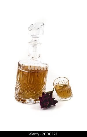 Decanter di cristallo con jigger e fiore per bevande alcoliche Foto Stock