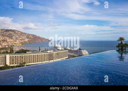 Portogallo, Madeira, Funchal, Vista dalla piscina infinity sul tetto del nuovo Royal Savoy Hotel che guarda verso il Pestana Casino Hotel e il terminal delle navi da crociera Foto Stock