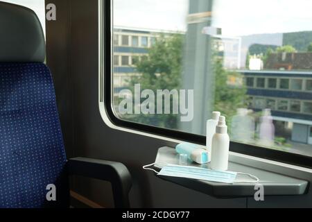 Treno interior commuter a Zurigo in Svizzera con maschera facciale e disinfettante per le mani come misura per combattere il coronavirus e covid-19 in trasporto. Foto Stock