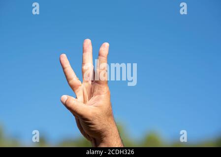 Mano dell'uomo che conta tre Foto Stock