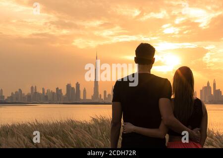 Due amanti in vacanza guardando la vista della città durante uno splendido tramonto cielo sfondo. Romanticismo, amore, incontri e viaggi. Foto Stock