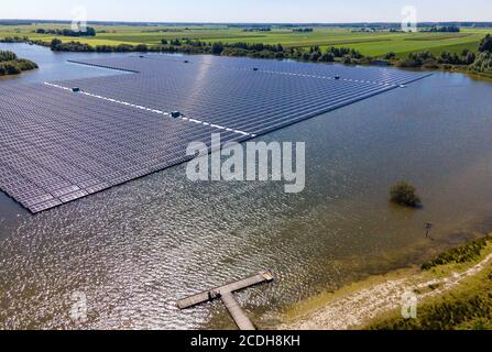 Persone sul molo godendo di un bellissimo paesaggio con pannelli solari galleggianti in acqua in ampio paesaggio. Foto Stock