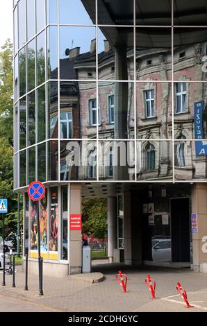 Cracovia. Cracovia. Polonia antichi edifici di affito si riflettono nella facciata di vetro del nuovo edificio per uffici. Foto Stock