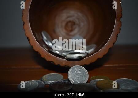 Monete in vaso di legno. Business, finanza, investimenti, risparmio di denaro e concetto di budget. Con percorsi di ritaglio. Foto Stock