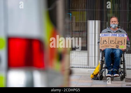 Londra, Regno Unito. 28 agosto 2020. Un uomo si siede su una sedia a rotelle di fronte al Centro Shell, sede centrale di Shell UK Ltd., come parte di una protesta di ribellione per l'estinzione. La campagna di oggi, ‘Lies, Lobying and Greenwashing’, chiede alla Shell di fermare tutte le esplorazioni per nuovi petrolio e gas, e di avviare un processo rapido e continuo per porre fine all’estrazione dei combustibili fossili. Credit: Neil Atkinson/Alamy Live News. Foto Stock