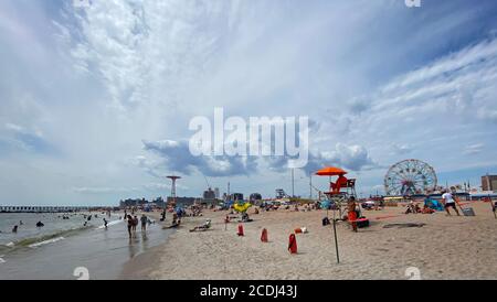 Sulla spiaggia di Coney Island nell'estate 2020 durante il Covid-19 Pandemic. Da agosto la maggior parte della gente ha sparato le loro maschere mentre all'oceano. Foto Stock