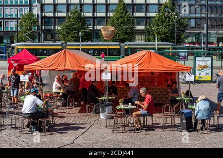 Le persone si gustano un caffè in tenda nella piazza del mercato di Hakaniemi a Helsinki, Finlandia Foto Stock