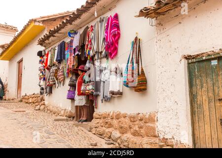 Chinchero, Perù - 05 ottobre 2018: Donna autoctona in un negozio con prodotti tessili alpaca fatti a mano e souvenir Foto Stock