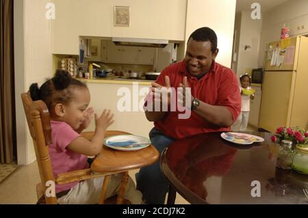 Pine Bluff, AR 16 ottobre 2006: Famiglia afroamericana con bambini piccoli che hanno cena da take-out di cibo messicano a casa. Versioni del modello disponibili. ©Bob Daemmrich Foto Stock