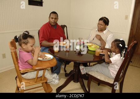 Pine Bluff, AR 16 ottobre 2006: Famiglia afroamericana con bambini piccoli che hanno cena da take-out di cibo messicano a casa. ©Bob Daemmrich Foto Stock