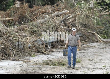 Marble Falls, Texas 28 giugno 2007: Chris Pounds del Marble Falls Street & Bridge Dept. Cammina attraverso gli alberi accatastati su un ponte della città mentre la pulizia continua dopo un'inondazione di luce il giorno prima. ©Bob Daemmrich Foto Stock