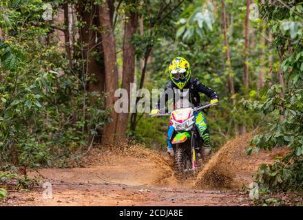 Donna che cavalca la sua bici da terra sulla pista forestale di Pak Chong / Thailandia Foto Stock