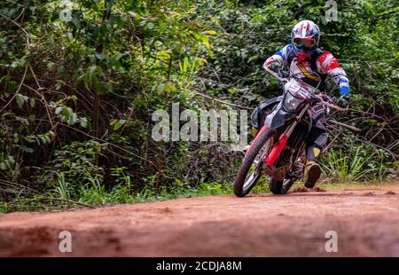 Uomo che velocizza la sua moto da terra su strada sterrata a Pak Chong / Thailandia Foto Stock