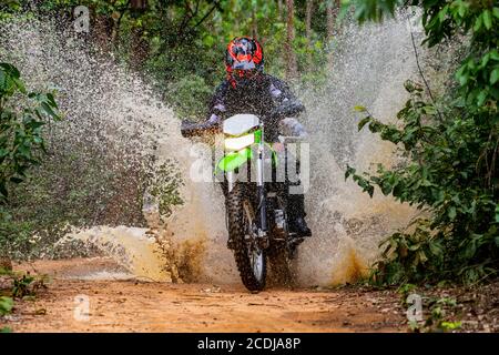Donna che cavalca la sua bici da terra sulla pista forestale di Pak Chong / Thailandia Foto Stock