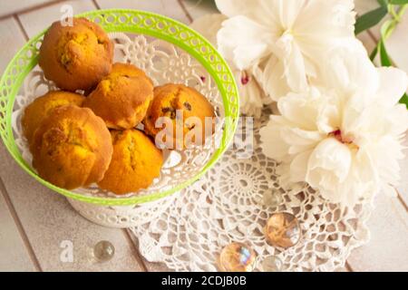 muffin fatti in casa. Prodotti da forno con pony bianco. Gustosi cupcake con fiori su tavola in legno shabby Foto Stock