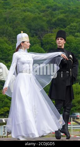 Adygea, RUSSIA - 25 2015 LUGLIO: Giovane ragazzo con una ragazza in Adyghe costumi nazionali danzare danza tradizionale in un ethnosurge nelle colline di Cau Foto Stock