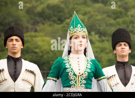 DAKHOVSKY, RUSSIA - LUGLIO 25 2015: Ragazzi e la ragazza in tute nazionali Adyghe contro la montagna. Il Festival 'Lago-Naki: Kunatskaya' si è tenuto nel m. Foto Stock