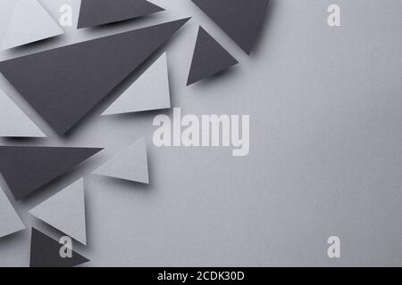 Sfondo astratto con forme triangolari nere e grigie su sfondo di carta grigio. Stile minimalista. Spazio di copia. Vista dall'alto Foto Stock