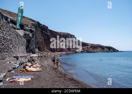 Santorini Grecia 2020 agosto, spiaggia rossa santorini in una giornata estiva con le persone prendere il sole Foto Stock